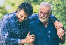 smiling son with arm around father